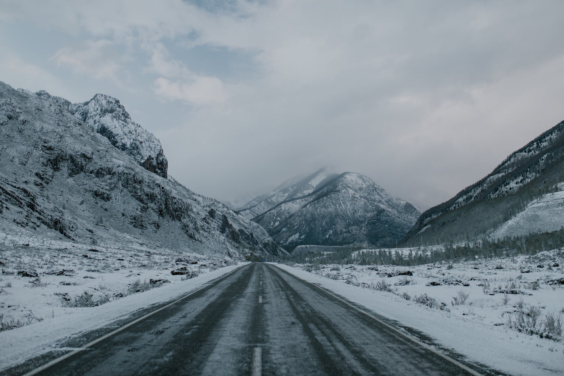 asphalt road through snowy mountainous terrain