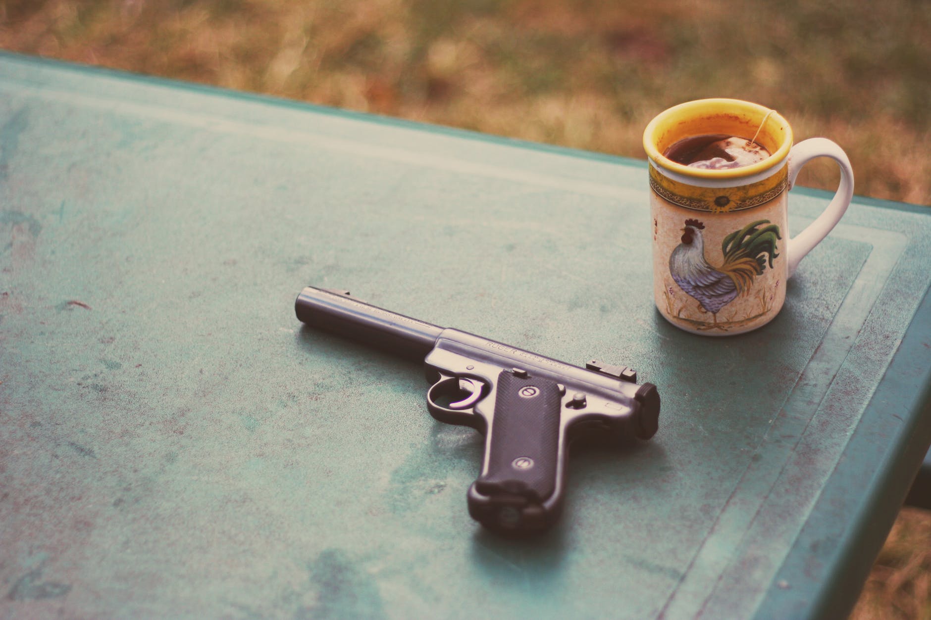 photo of handgun near mug